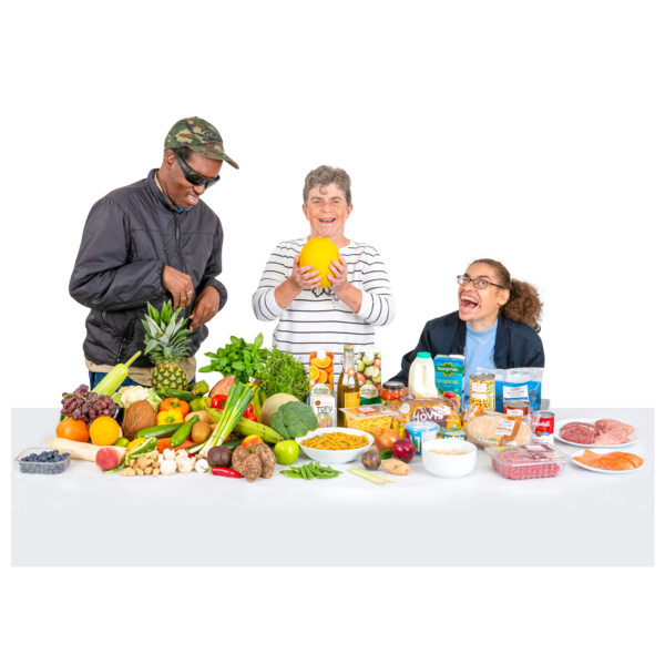three people looking at a table of food, including lots of fruit and vegetables