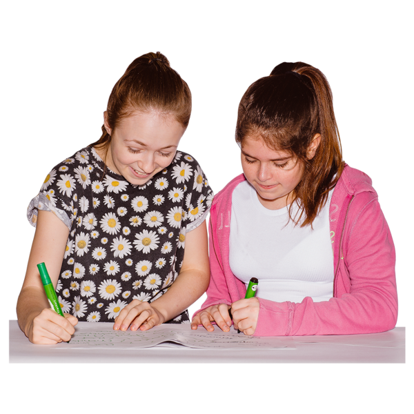 two school-age girls are writing on paper together